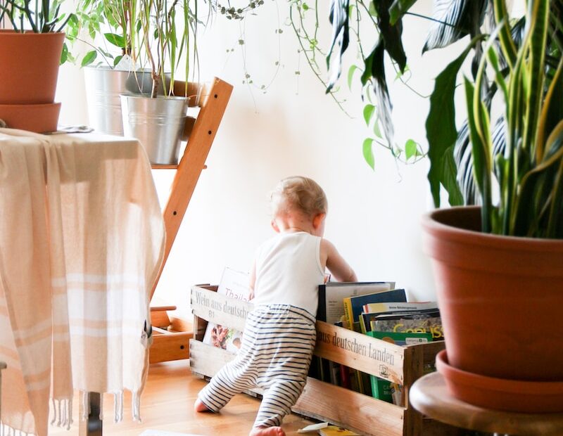 toddler wearing white tank top near white wall